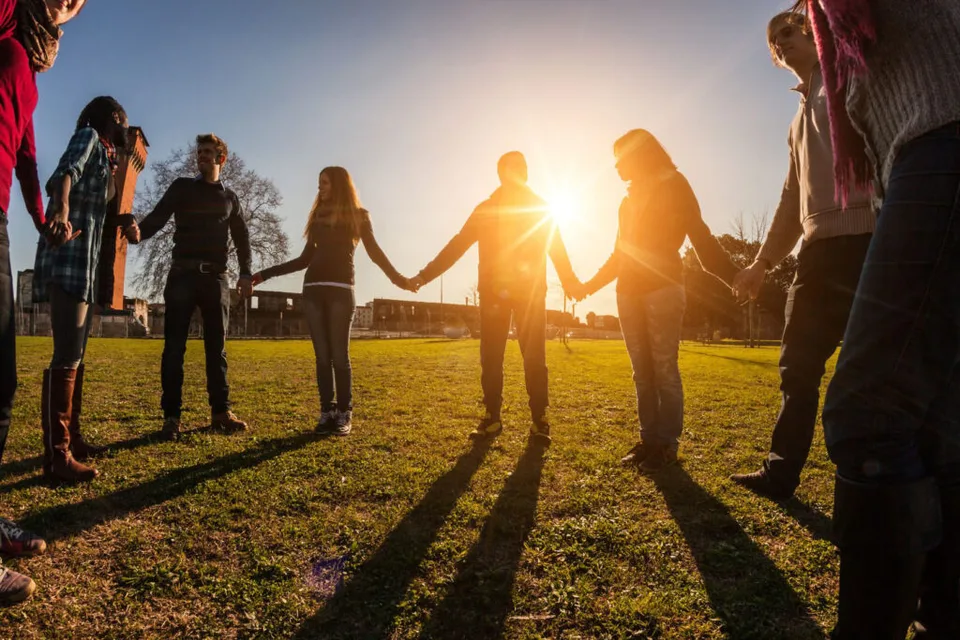 friends gathered in a circle holding hands