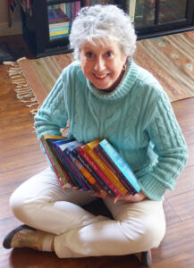 Cheryl in a seated position displaying some fo her books